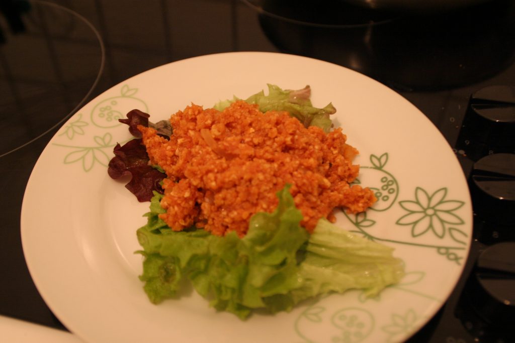 Veganes Mett aus Reiswaffeln auf einem Teller, garniert mit Salat. Wenn man auf das Bild klickt gelangt man zum eiweißarmen Rezept für Menschen mit PKU.